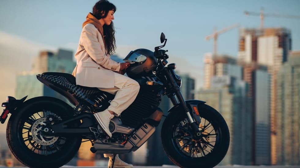 Woman in white sitting on a Livewire S2 motorcycle. 