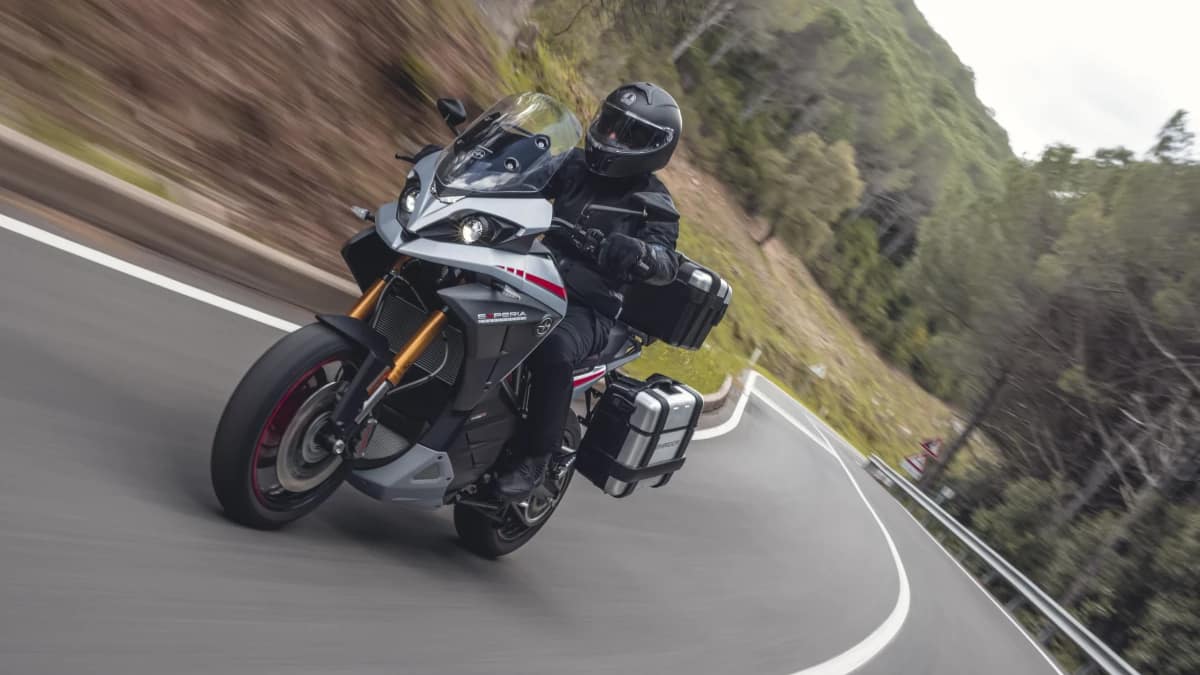 Electric touring motorcycle on a twisty backroad. 