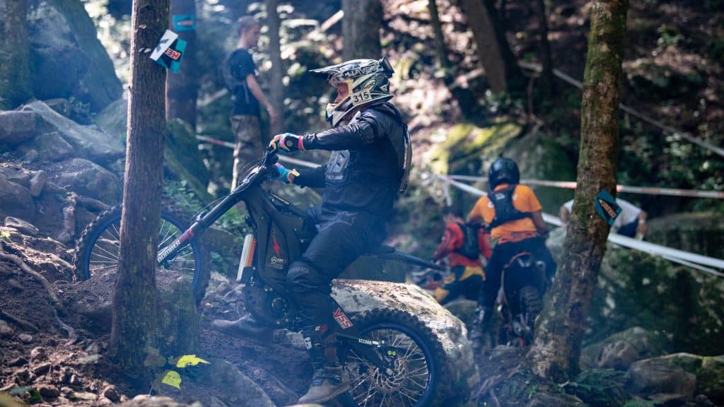 Electric enduro motorcycle takes on a muddy hill climb at the 2022 Redbull TKO race.