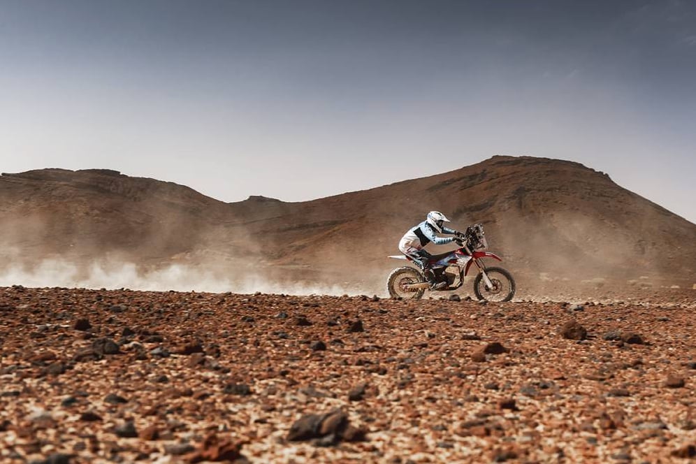 Rider on eMoto bike racing the Dakar mission 1000 rally.
