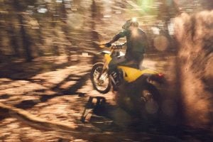 radian exr electric dirt bike throwing roost in the woods.