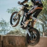 Jarv-E electric hard enduro bike clearing a concrete obstacle.